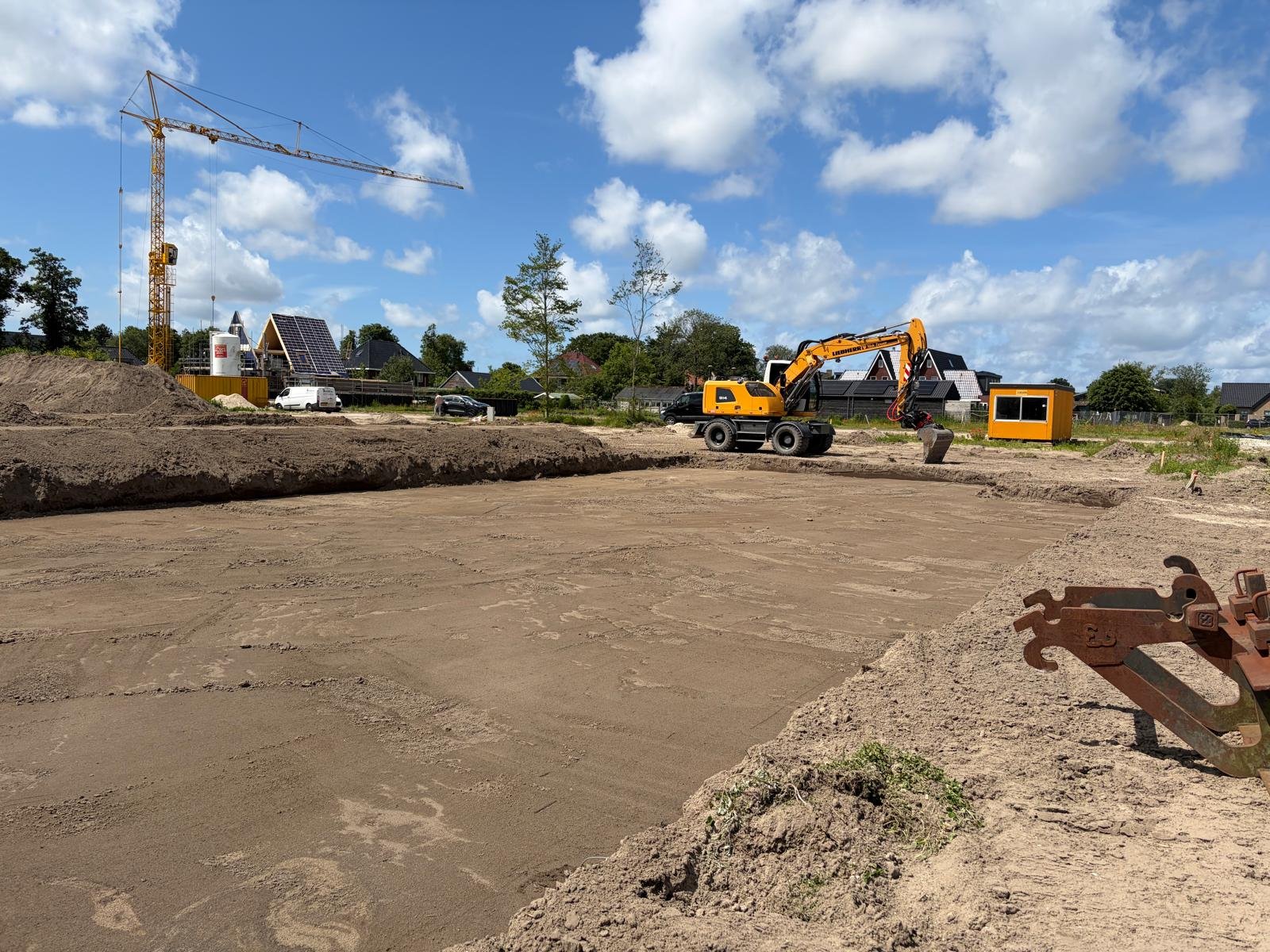 Grondwerk en bouwplaats met graafmachine en torenkraan