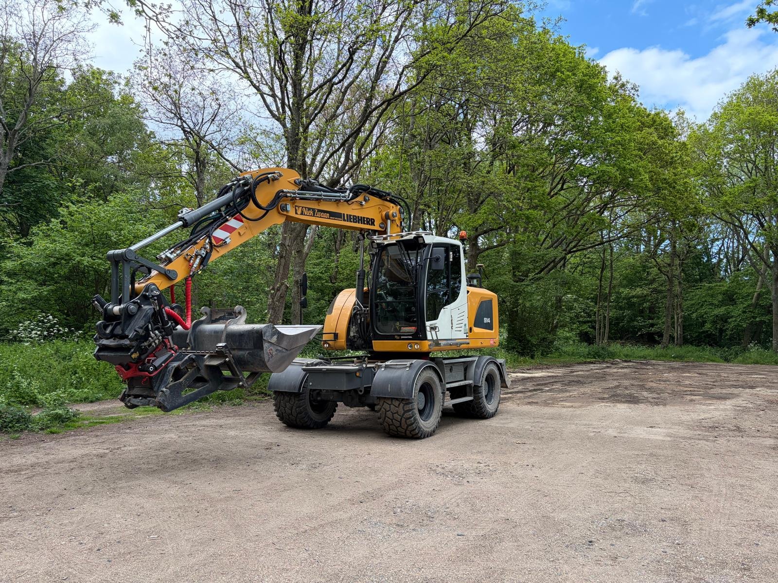 Liebherr graafmachine in bosrijke omgeving